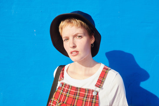 Short-haired girl in leather hat with septum.