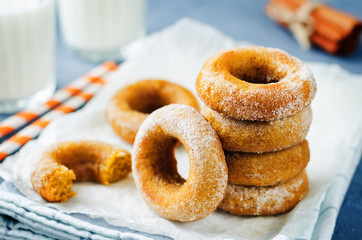 Baked pumpkin donuts with glasses of milk