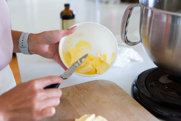 adding butter into bowl of stand mixer, mixing buttercream icing