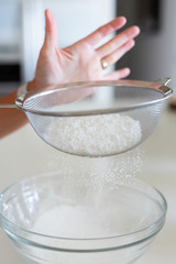 woman sifting powdered sugar