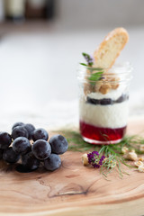 Vanilla Panna Cotta with a Concord Grape Gelee Topped with Whipped Chantilly Cream and Toasted Hazelnut and Served with a Slice of Hazelnut Biscotti