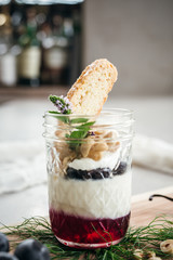 Vanilla Panna Cotta with a Concord Grape Gelee Topped with Whipped Chantilly Cream and Toasted Hazelnut and Served with a Slice of Hazelnut Biscotti