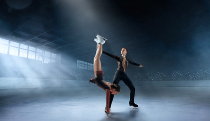 Fototapeta na wymiar Figure skating couple in professional ice arena.