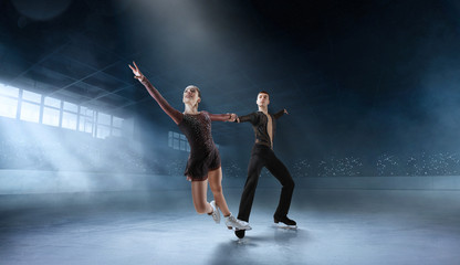 Fototapeta na wymiar Figure skating couple in professional ice arena.