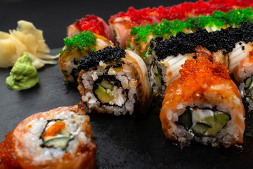 Sushi roll Philadelphia with salmon, smoked eel, avocado, cream cheese on black background. Sushi menu. Japanese food.