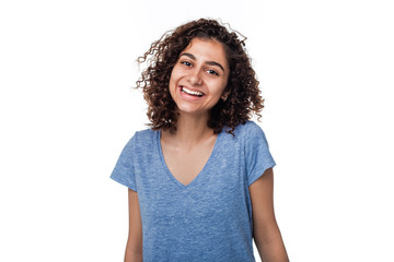 Portrait of a smiling Indian brunette young woman. Joyful mixed race girl on a white isolated background. Happy beautiful female in t-shirt.  