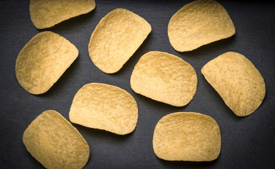 Stock of potato chips on black background. Many potato chips on black background