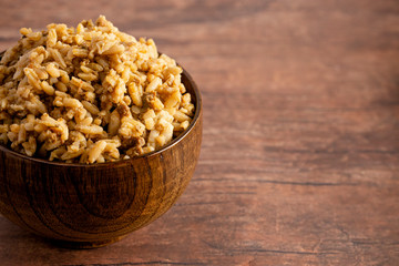 Bowl of Cajun Dirty Rice on a Rustic Wooden Table