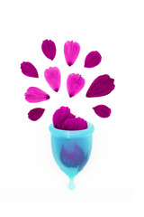 a woman personal hygiene item for period, a blue menstrual cup filled with flower petals, like metaphor of a drop of blood splashing overflowed on a white background