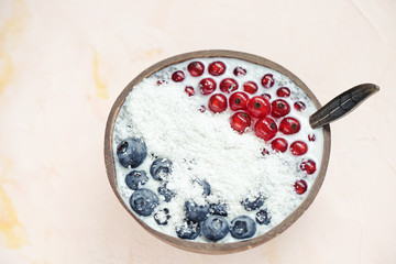 Chia seed pudding with blueberries, red currant berries and coconut flakes in a bowl