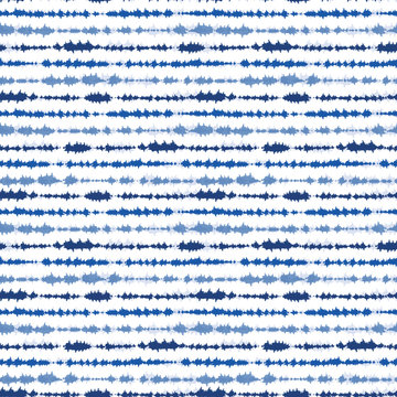 Indigo blue shibori tie dye horizontal stripe. Seamless pattern background. Japanese style batik textile. Variegated for summer fashion swatch.