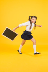 Schoolgirl pupil informing. School girl hold blank chalkboard copy space. Follow me. Announcement and promotion. Girl school uniform hold blackboard going. Back to school concept. Making step