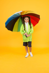 Rain is not so bad if you have water resistant clothes. Carefree schoolgirl colorful umbrella wear waterproof rain coat. Autumn rain. Going to school rainy days more fun with bright accessories