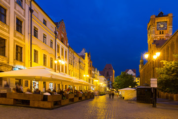 Fototapeta na wymiar Night view of Torun streets and building illuminated at dusk
