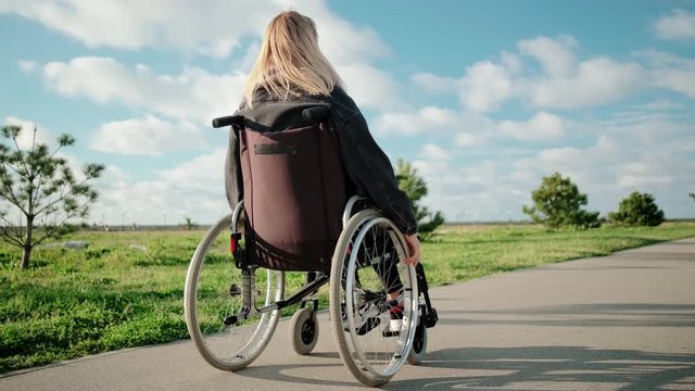 Quiet lonely walk of handicapped woman in wheelchair