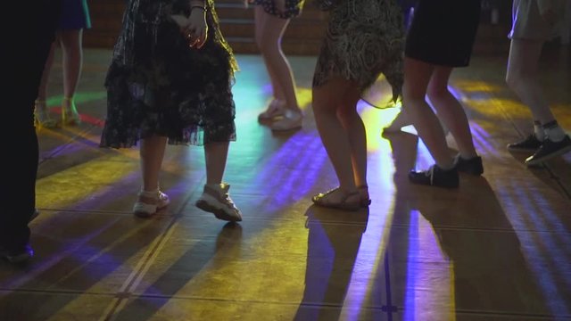 dancing legs in a nightclub. silhouette of legs of dancing people on latino salsa party with multi-colored iridescent lights