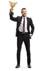 Happy young man in a suit holding a golden trophy cup