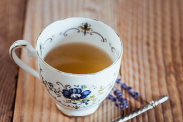 Thé au citron dans une tasse en porcelaine, table en bois
