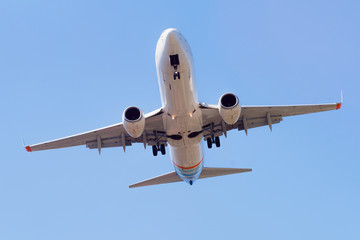 Passenger airplane landing in the airport runway. Passenger plane and blue sky with clouds. Details of airplane landing .