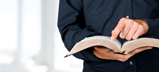 Man reading old heavy book on background