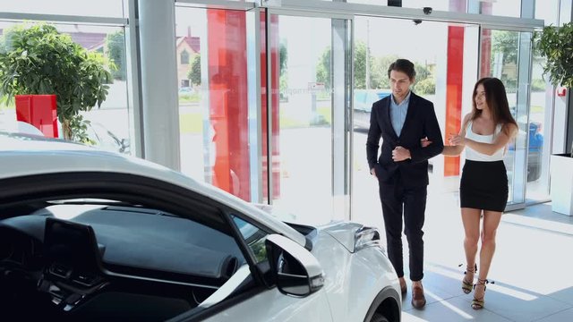 couple entering a car dealership to purchase a car for wife