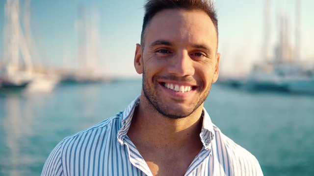 Young rich man at Yacht Club. Businessman is smiling and Relaxing in the gulf with seaview and luxury ships