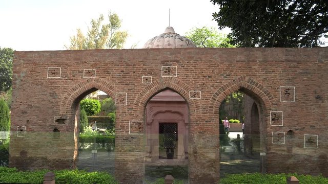 wide view of a bullet marked wall at jallianwala bagh memorial in amritsar, india