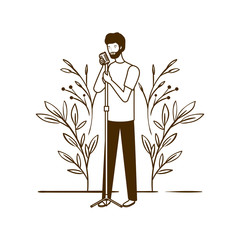 silhouette of man with microphone and branches and leaves in the background