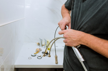 Fototapeta na wymiar Plumber holding a faucet plumbing assemble repair service