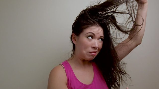 Female hair model messing with stringy straight hair, upset troubled expression.