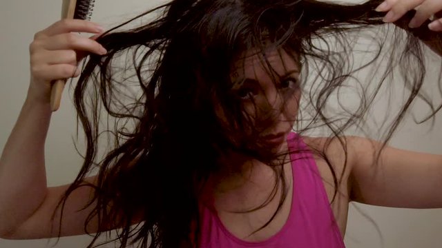 Female hair model messing with stringy straight hair, upset troubled expression.