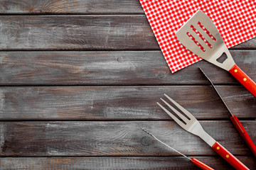 Tongs, fork, spatula for barbecue and grill on wooden background top view space for text