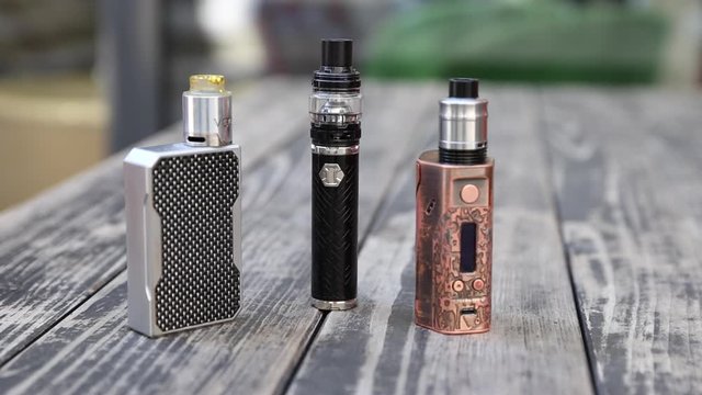 Vape Brown Tobacco Juice Tank Refill. Vaping eCigarette Tools in Background.