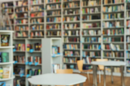 Blurred View Of Bookshelves And Tables In Library