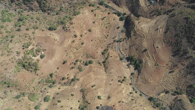 Overhead drone shot of small dried up river in mountain valley Ethiopia