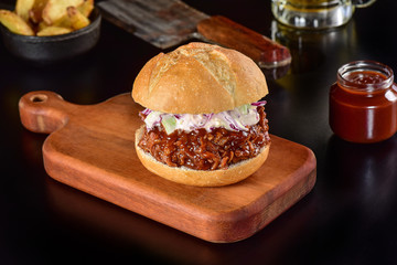 Pulled pork sandwich on rustic decorated scene