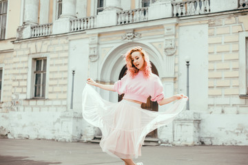 Young brunette girl in black standing outside and watching the sunset in the city, the sun shines brightly, fashionable clothes on a girl, hipster style,, tattoo, street, freedom, pink color, moodl