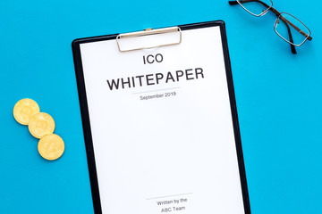 Initial coin offering ICO white paper on blue background top view