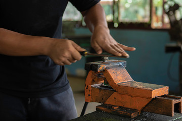 Men are using rasp the hammer to sharpen and put the hammer.