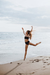 Beautiful young woman posing on the beach with a yellow tissue. Happy smiling girl with scarf enjoying at beach. Freedom and carefree concept,Bali, happy face, smile,sport,Yellow color,waves,tanning