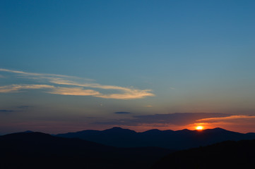 Weather-worn cedar bSunset view from the top of Chimney Mountain in the Adirondack Mountain Rangearn overlooking the landscape in the Adirondack Mountains under a troubled sky