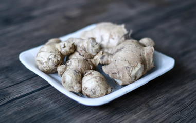 Ginger or Zingiber officinale on wood background. Used as a spice and a folk medicine.