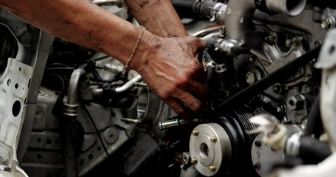 Auto mechanic working on car engine in mechanics garage. car service, repair, maintenance and people concept