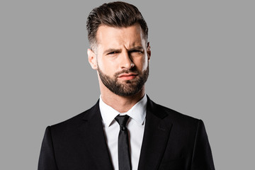 skeptical handsome businessman in black suit isolated on grey