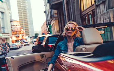 Beauty woman posing with red car in the street,fashion model,outdoor crazy portrait,Single laughing young woman with hat and sunglasses driving her convertible top automobile on bright sunny day, USA