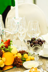 Party dinner table setting with tableware and silverware and glasses set and Candlestick and flower in restaurant.