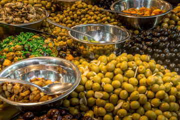 Fresh green and black olives in silver bowl at a market