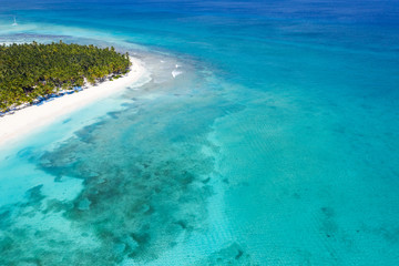 Fototapeta na wymiar Aerial view on tropical island with palm trees and caribbean sea