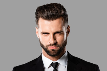 portrait of angry handsome businessman in black suit isolated on grey