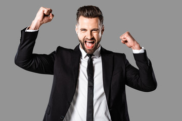 happy businessman in black suit showing yes gesture isolated on grey